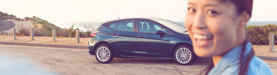 A Woman Standing in Front of a Holden Astra Hatch