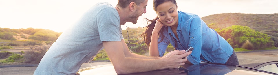 A Couple Looking at a Phone on the Roadside